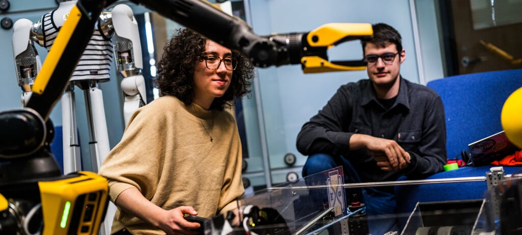 Students controlling a robotic arm