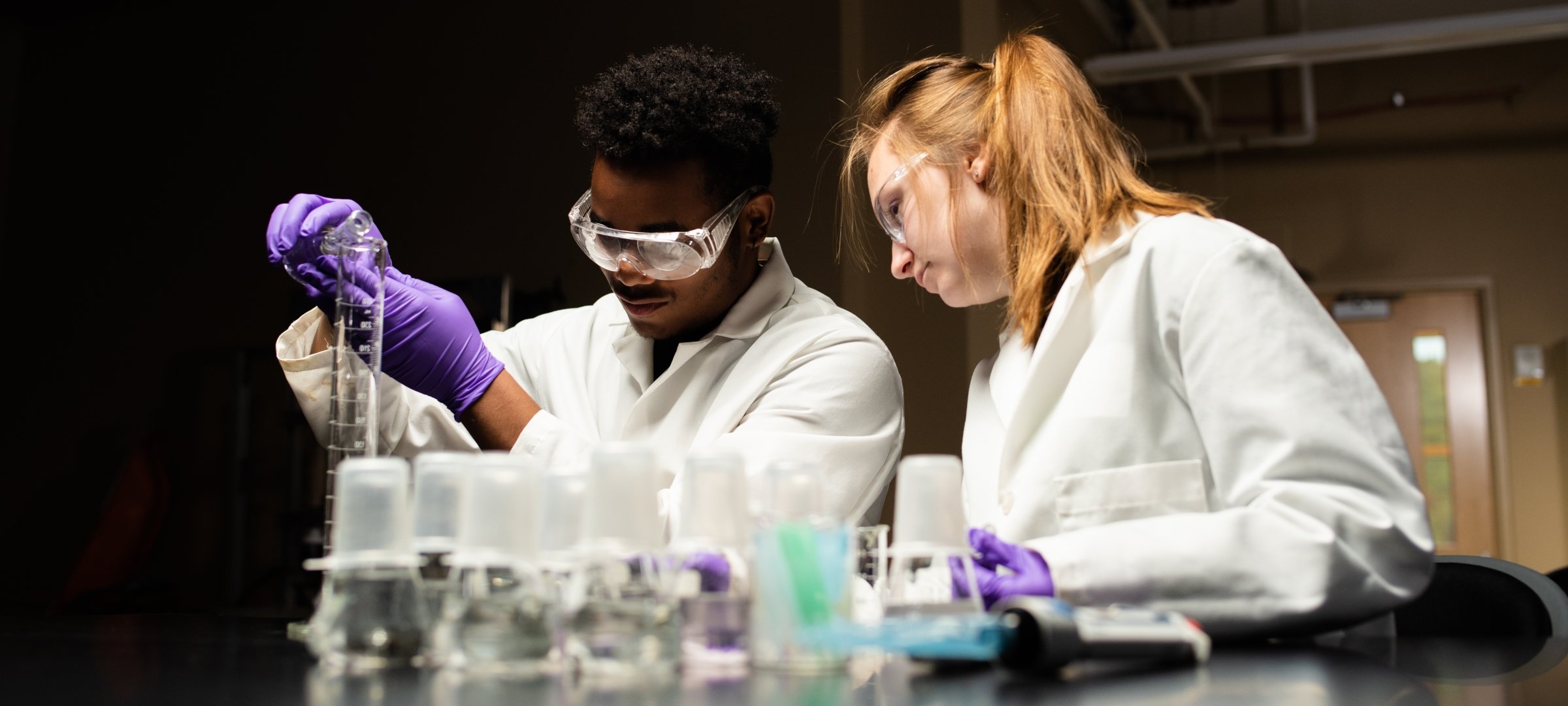 Man and woman work in a chemicals lab.