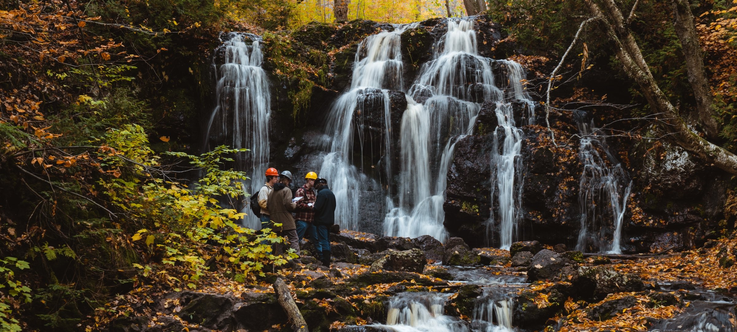 Students doing field research near a waterfall
