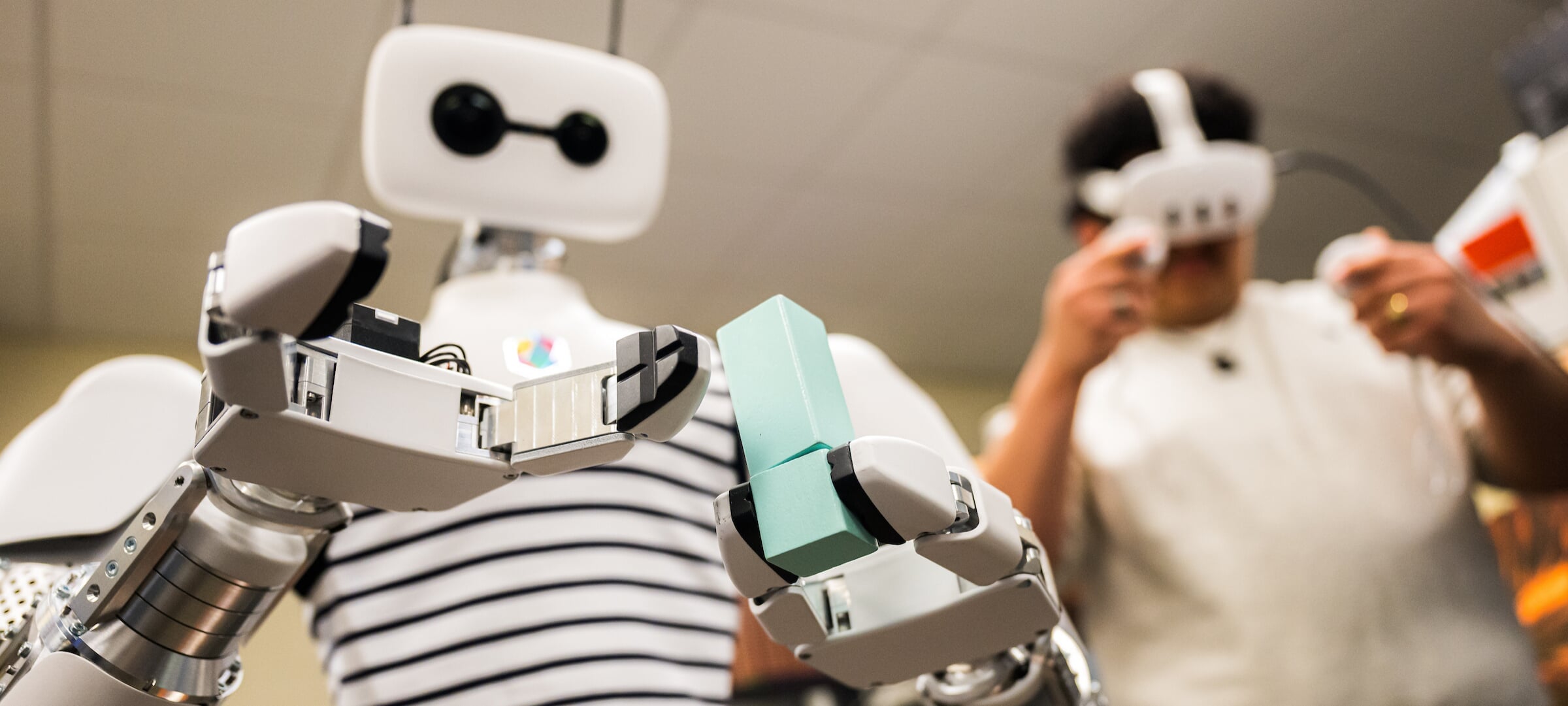Student researcher controls Reachy the Robot with a VR headset and hand controllers