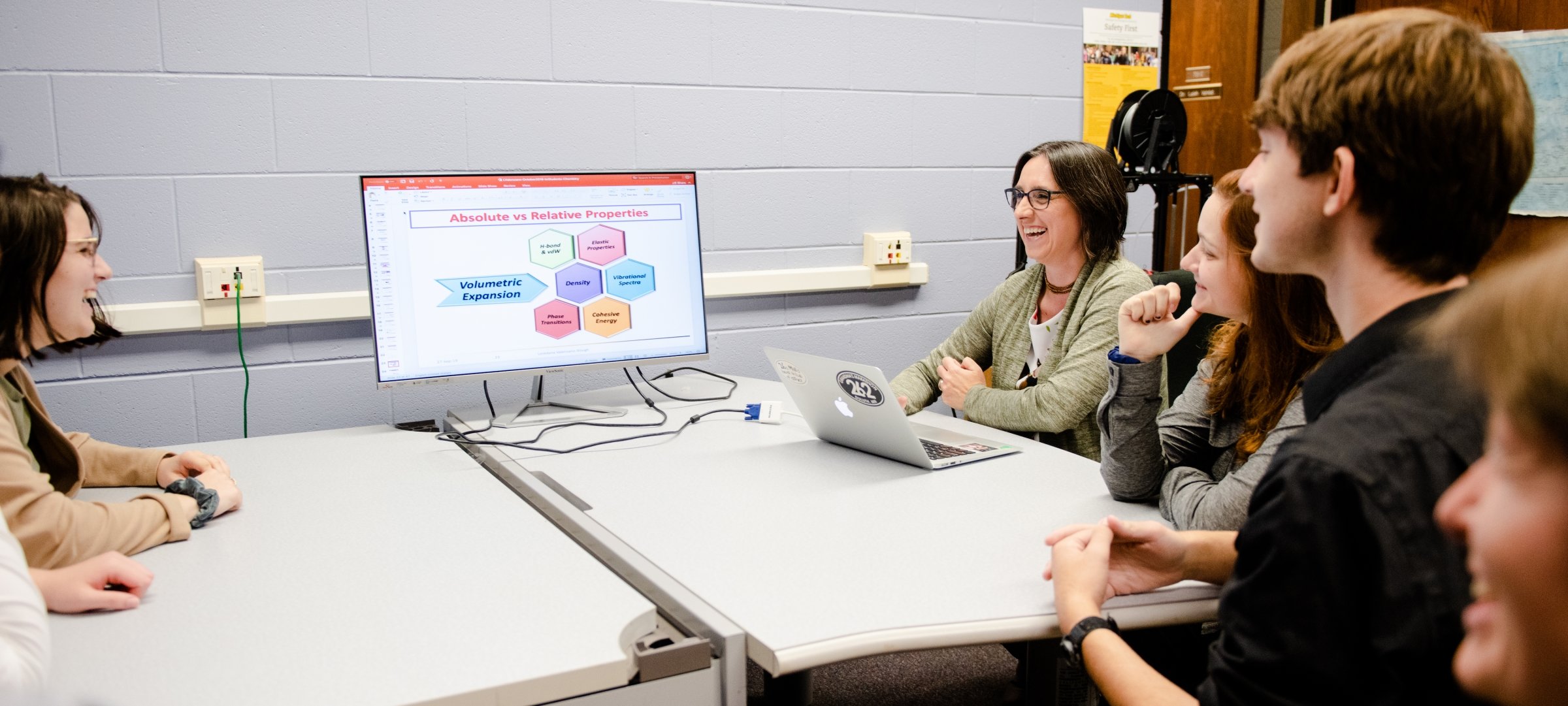 Cheminformatics students discussing data on a monitor.