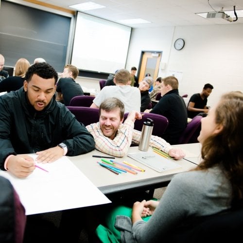 Busimess students in class talking to a professor