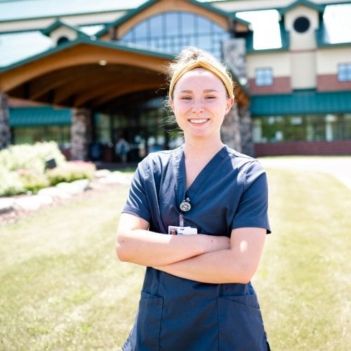pre-health student in scrubs outside the local hospital