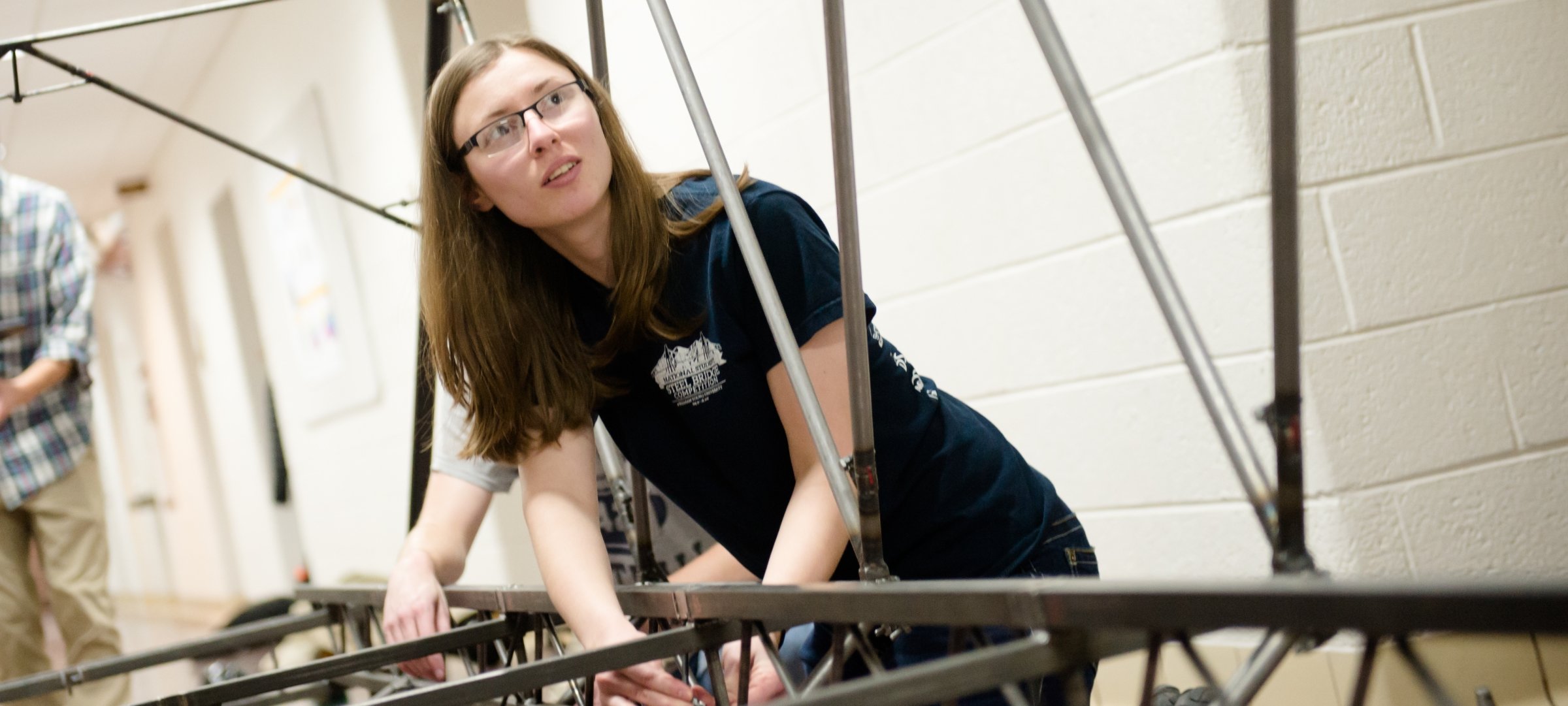 Engineering students working together on a steel bridge.