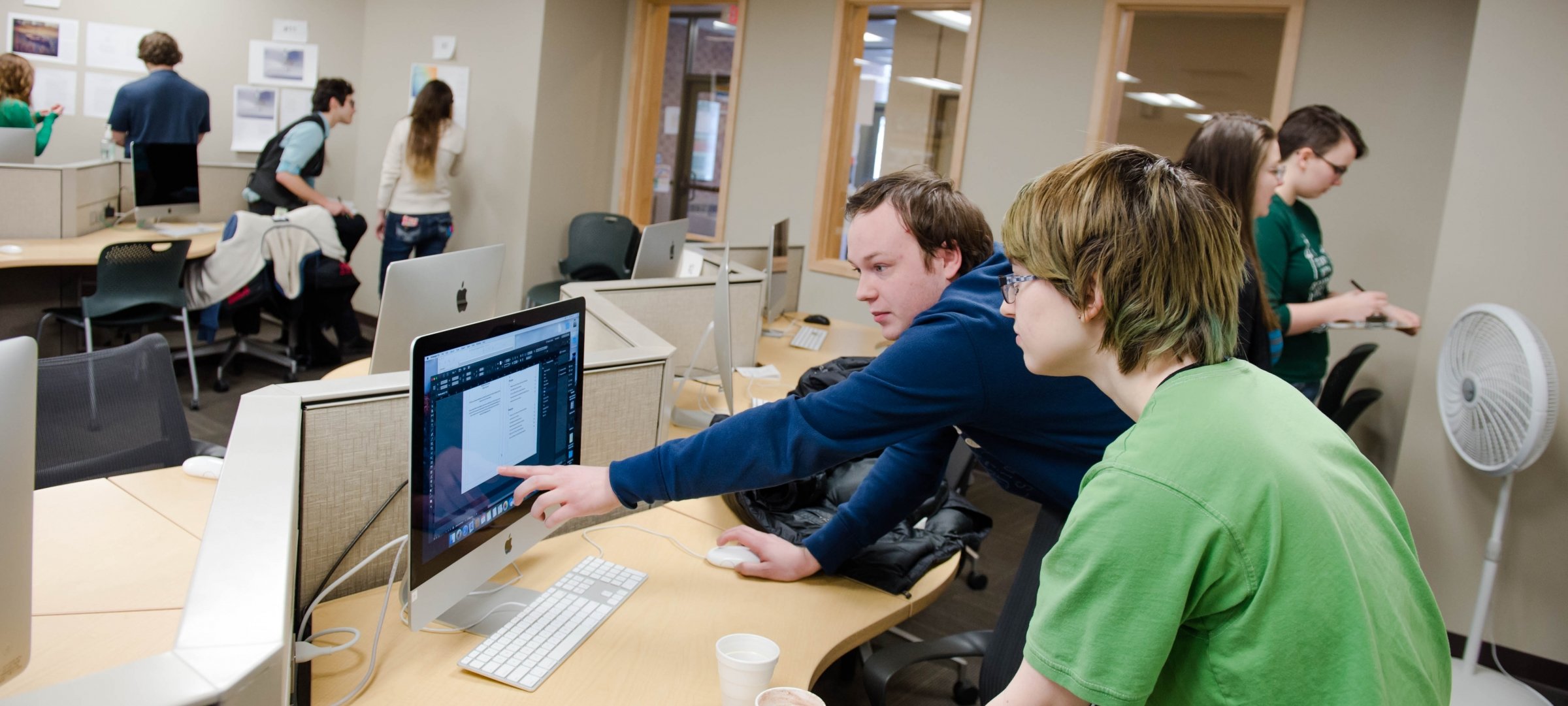 Humanities students working on media on a computer.