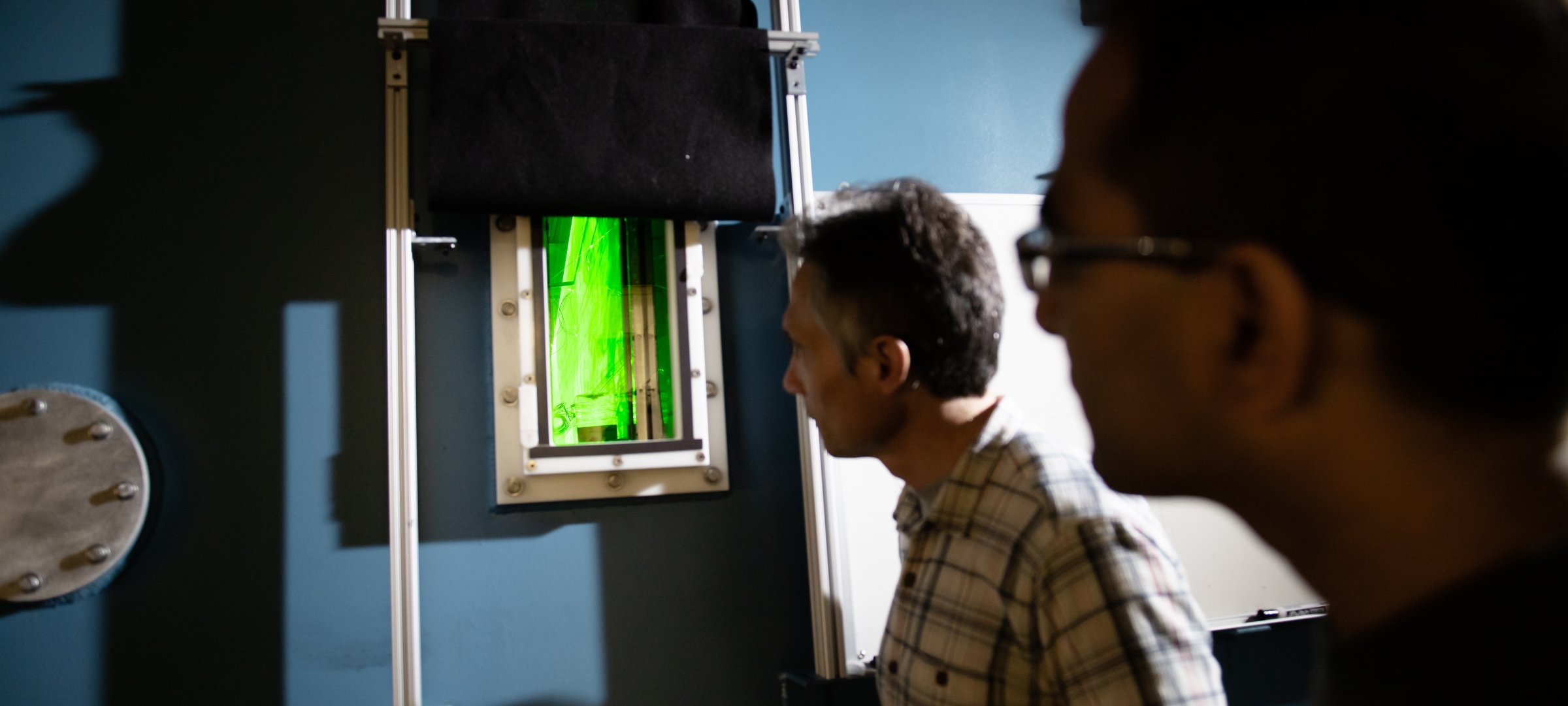 Physics faculty members looking inside the cloud chamber.