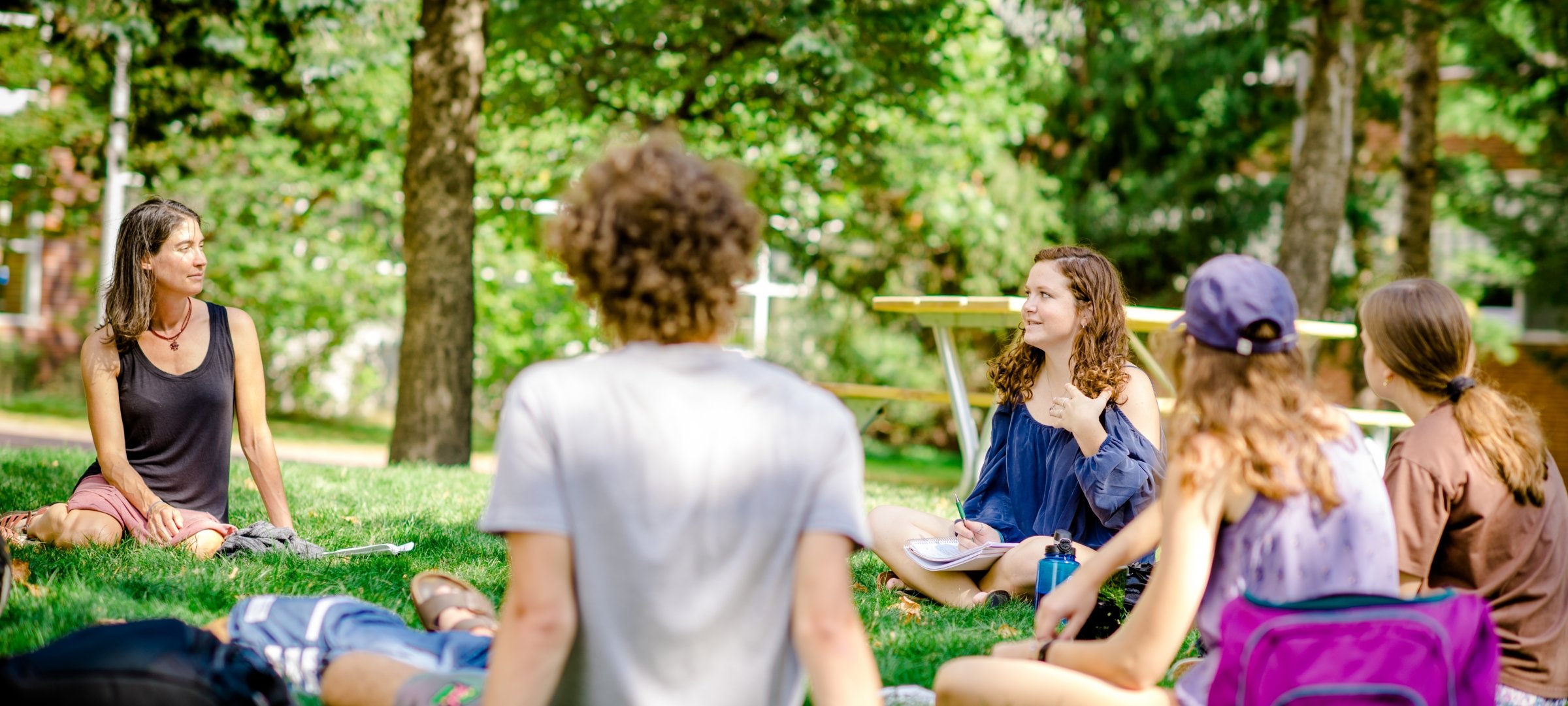 Students talking in the grass on the Husky Plaza