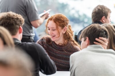 Students working together at a table, with one student in focus.