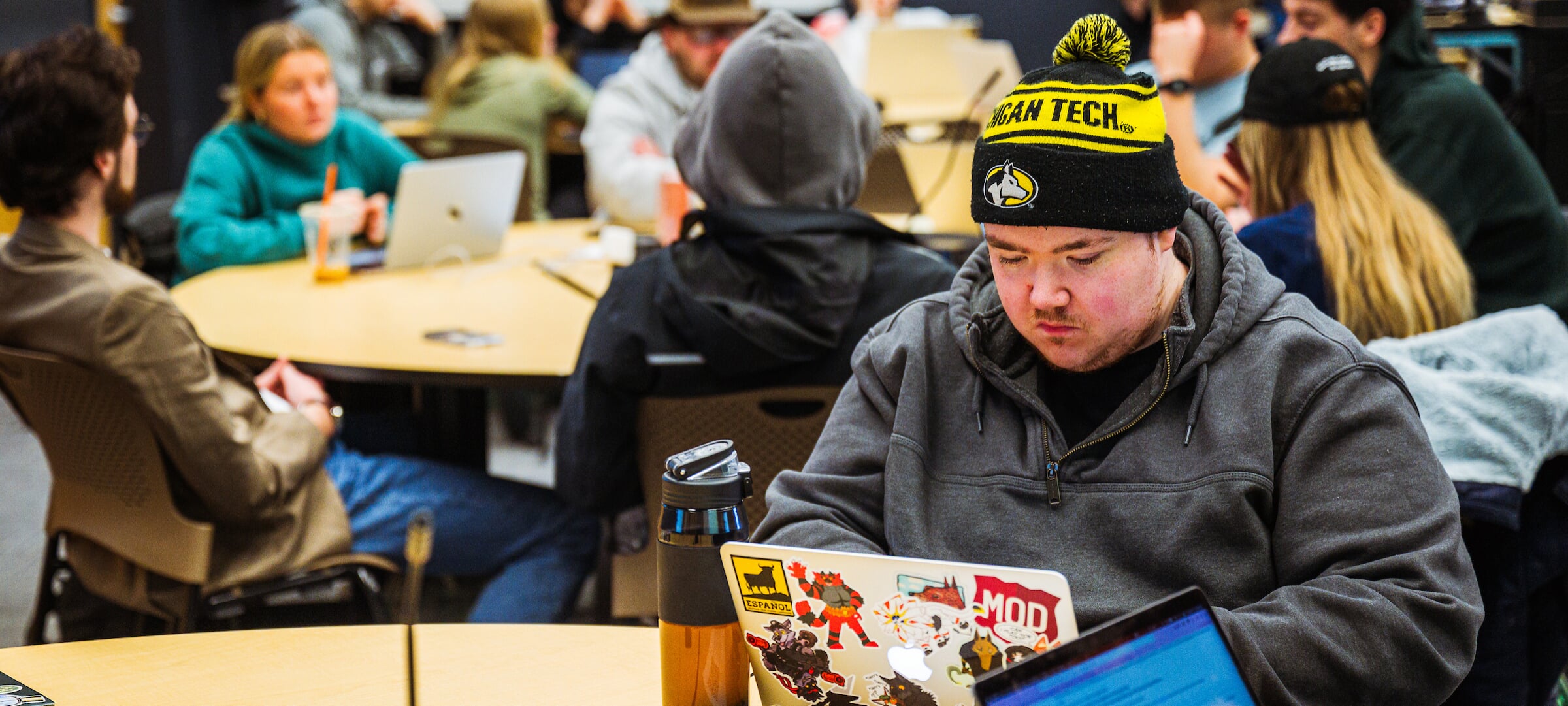 Guest student sitting at a table with a laptop.