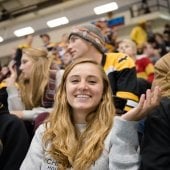 Fans smiling at a hockey game.