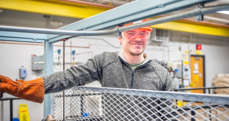 Student standing in front of OU Lab equipment.