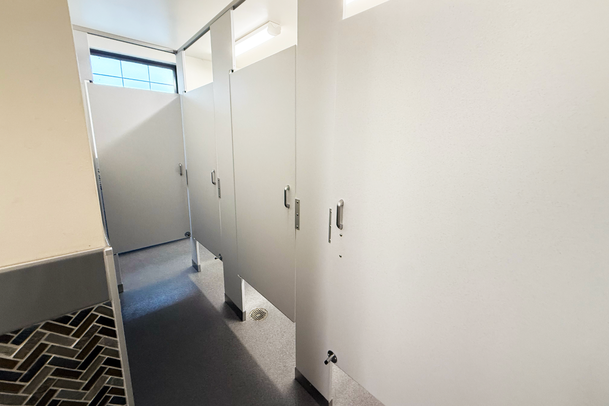 A row of toilet stalls in the bathroom.