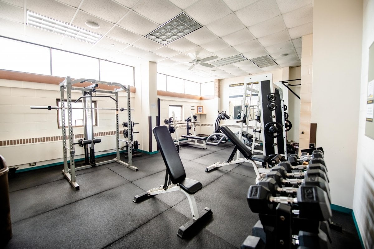 Fitness room with free weights and weight benches.
