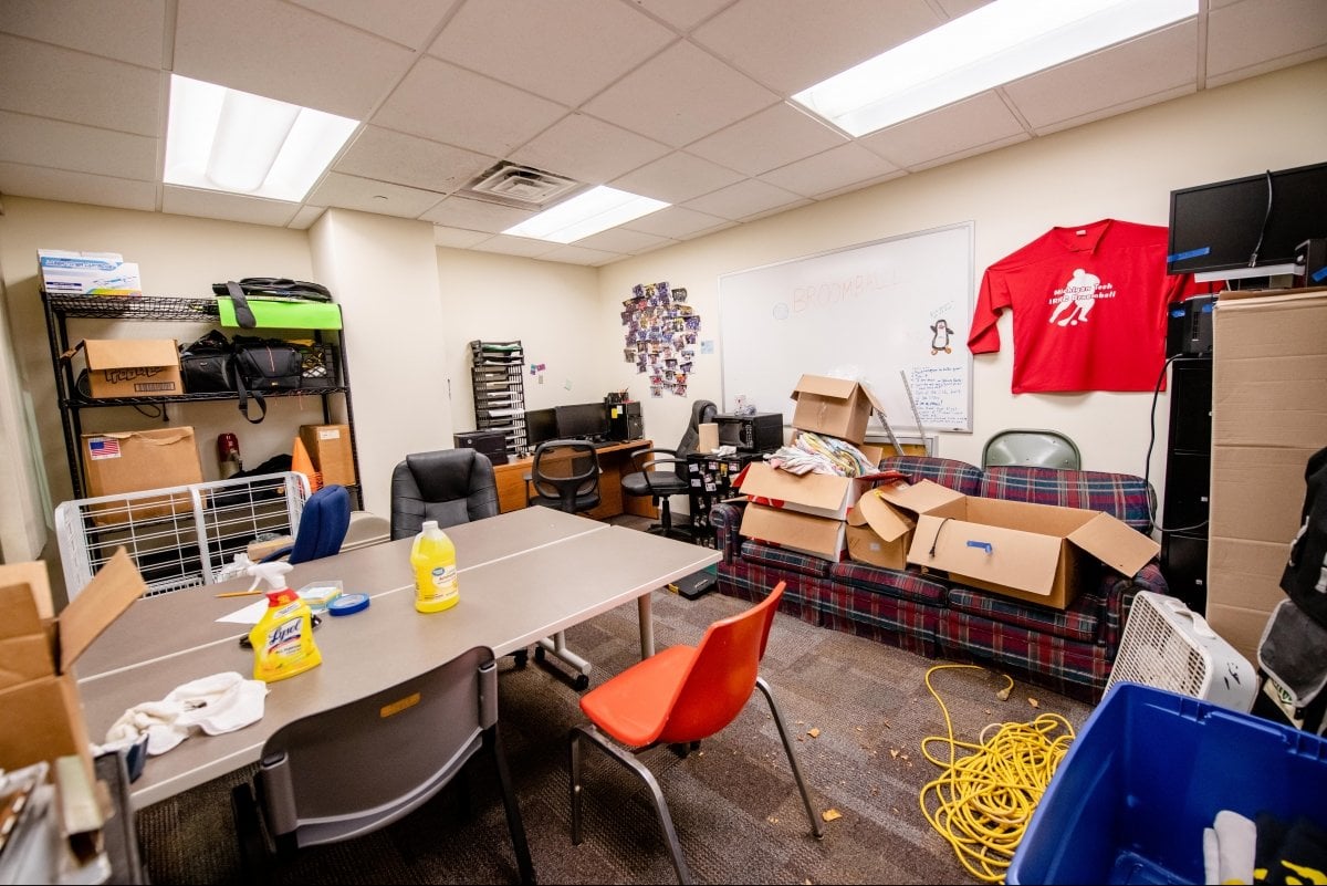 Broomball office with tables, chairs, and boxes.