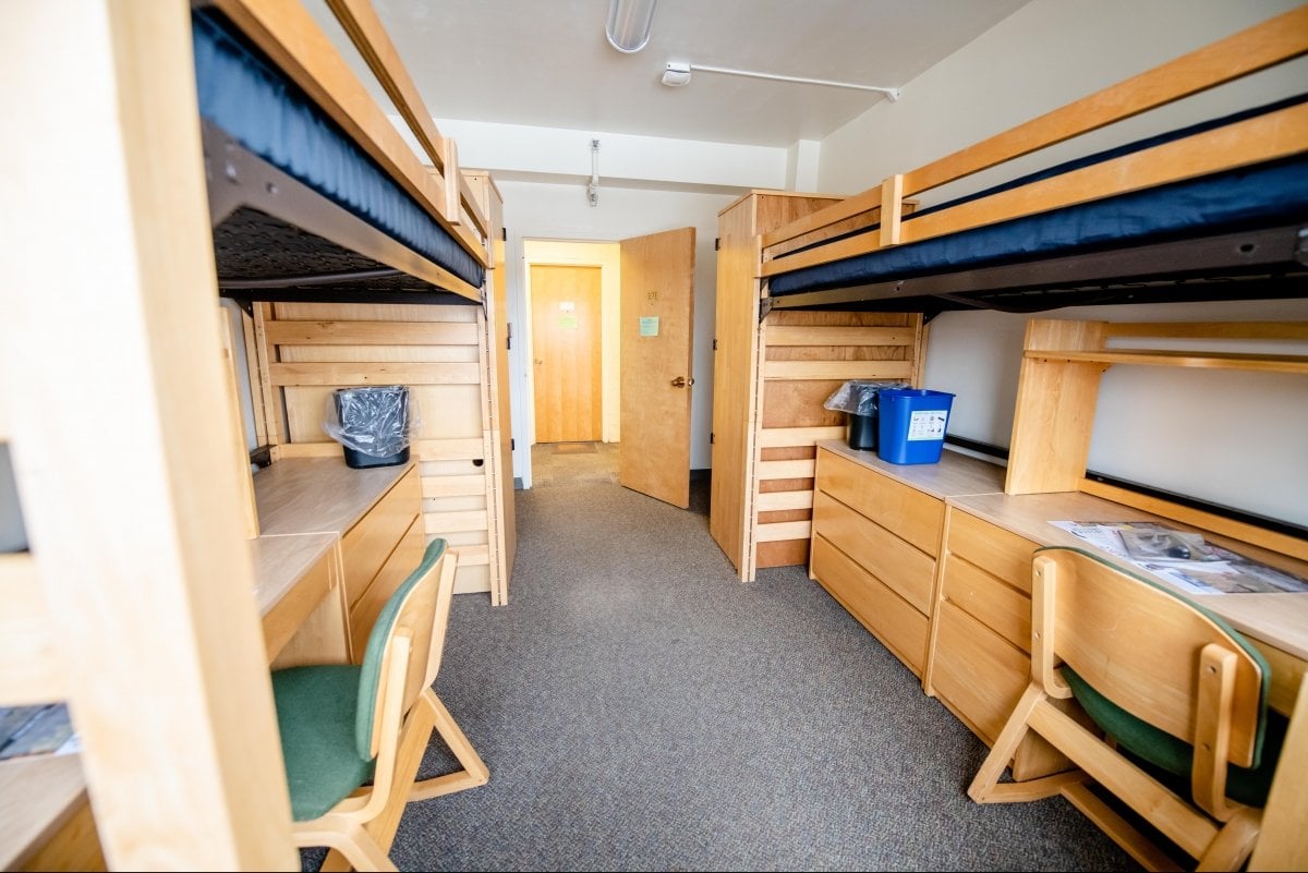 Looking from inside the room, showing two loft beds with desks below and wardrobes.