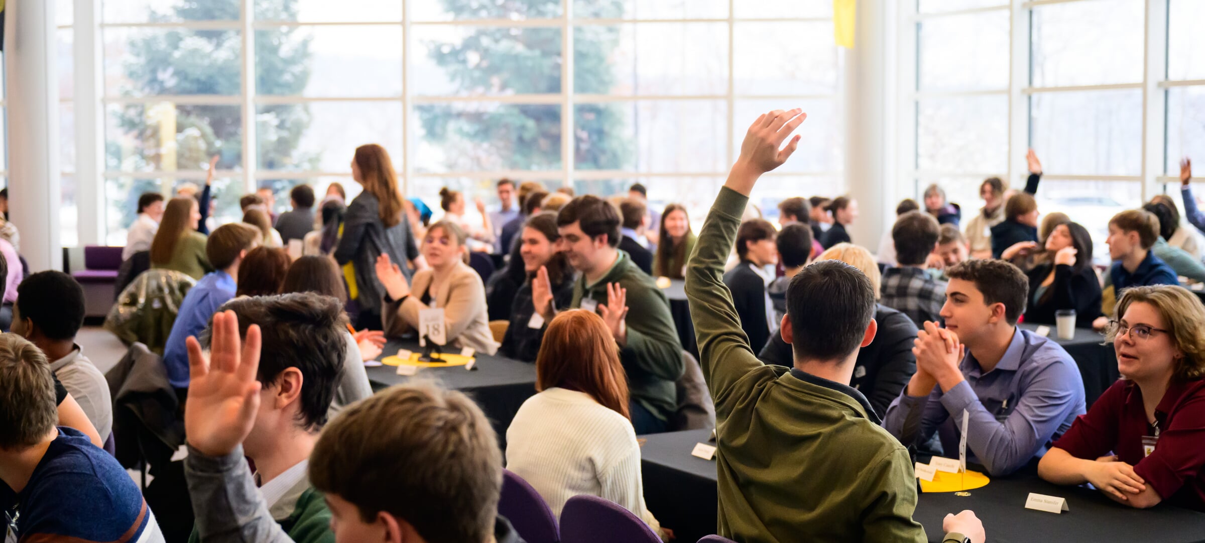 Students raising hands during activity