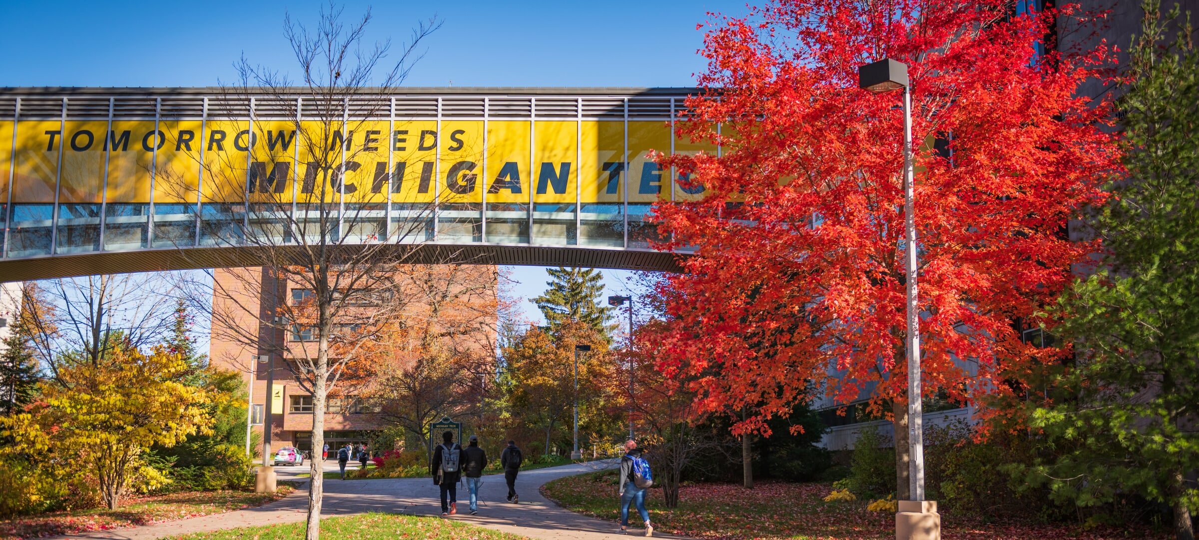 Campus Tomorrow Needs Michigan Tech walkway bridge during fall.