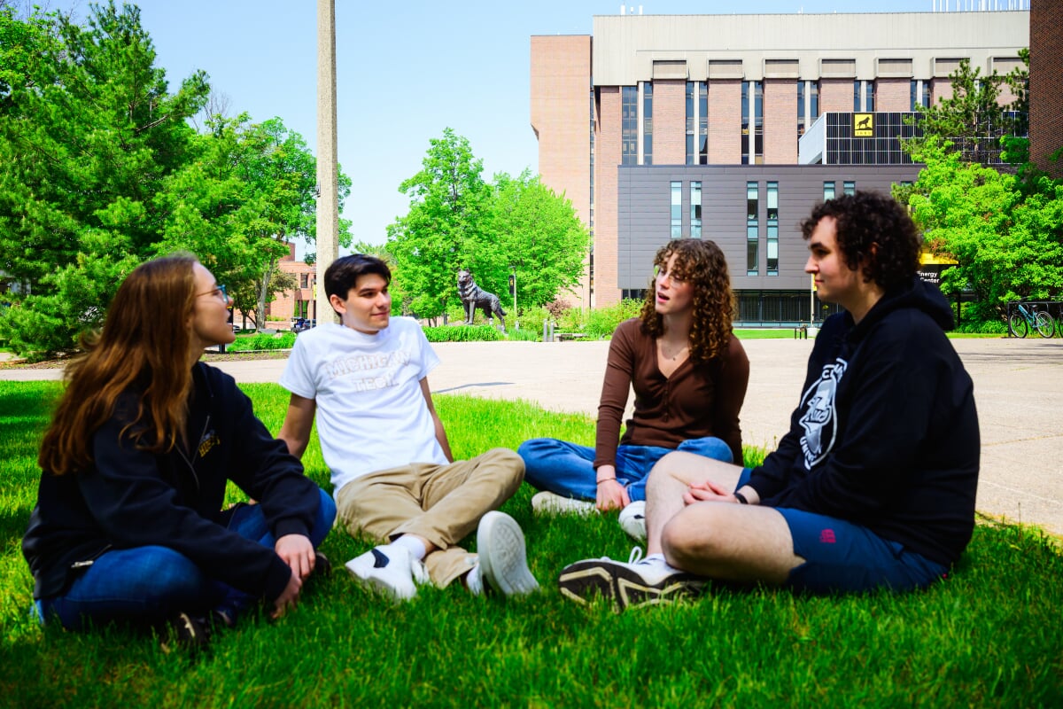 Students sitting on the campus lawn in a circle