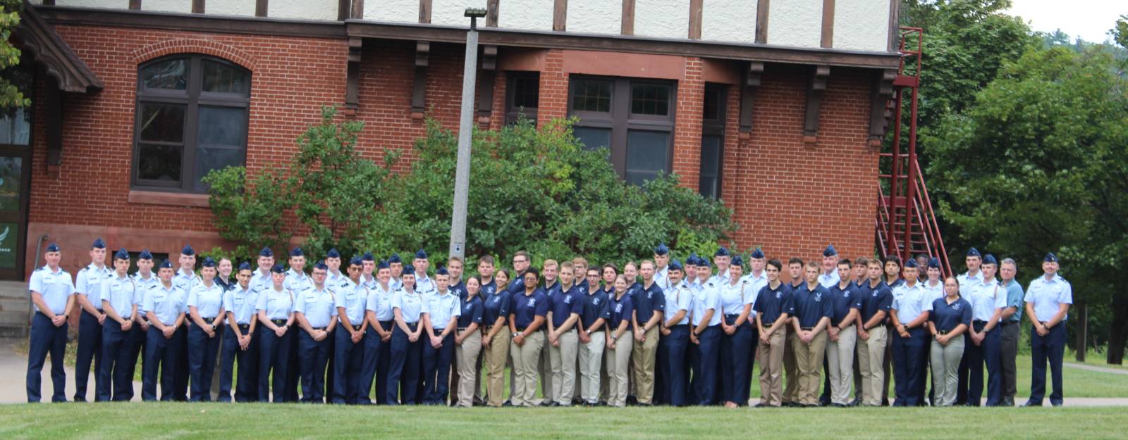 Air Force ROTC cadets in Blues standing in front of the Michigan Tech ROTC building.