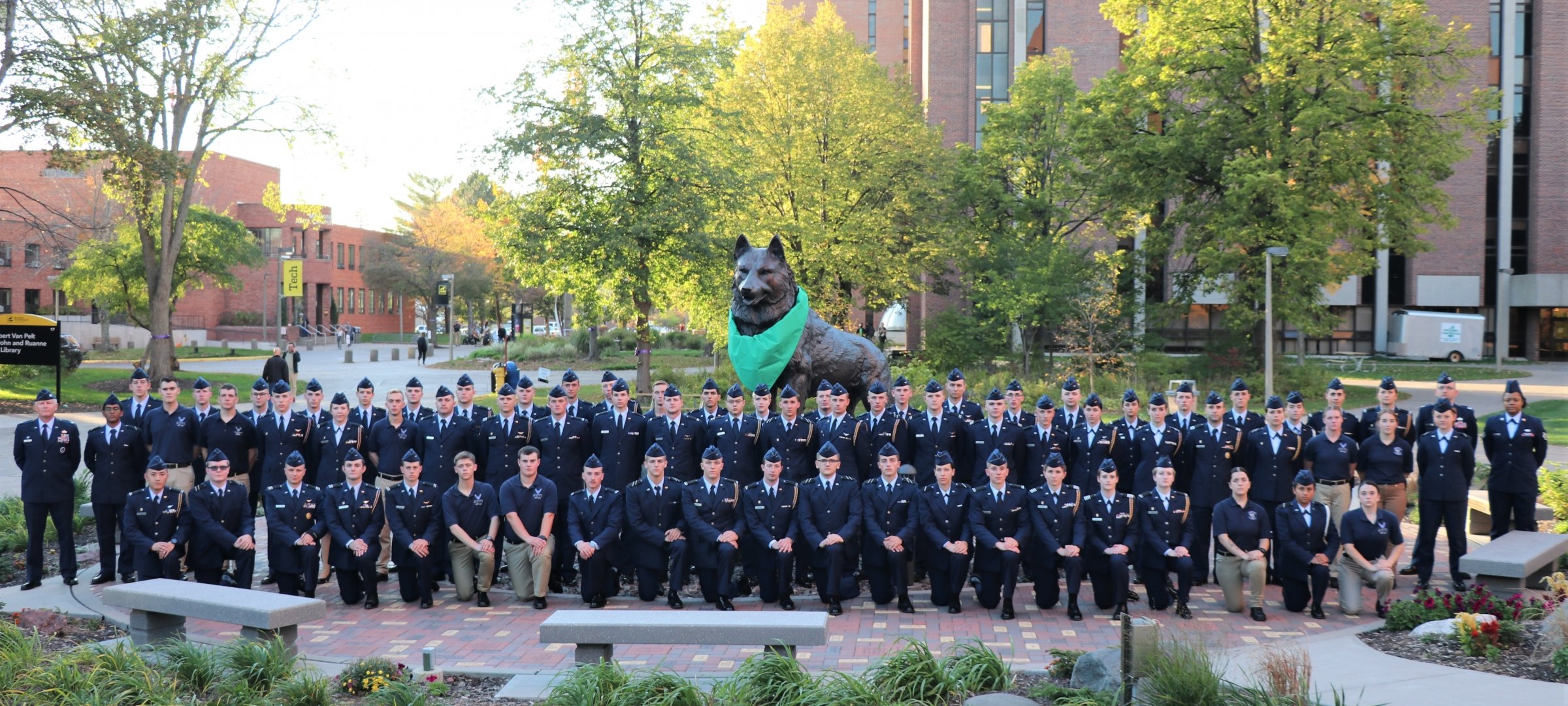 Air Force ROTC cadets in ABU's standing in front of the Michigan Tech Husky statue at the center of campus..