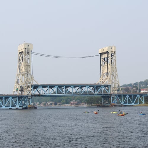 Group of kayakers in front of lift bridge