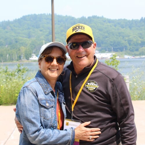 Man and woman smiling in front of lake