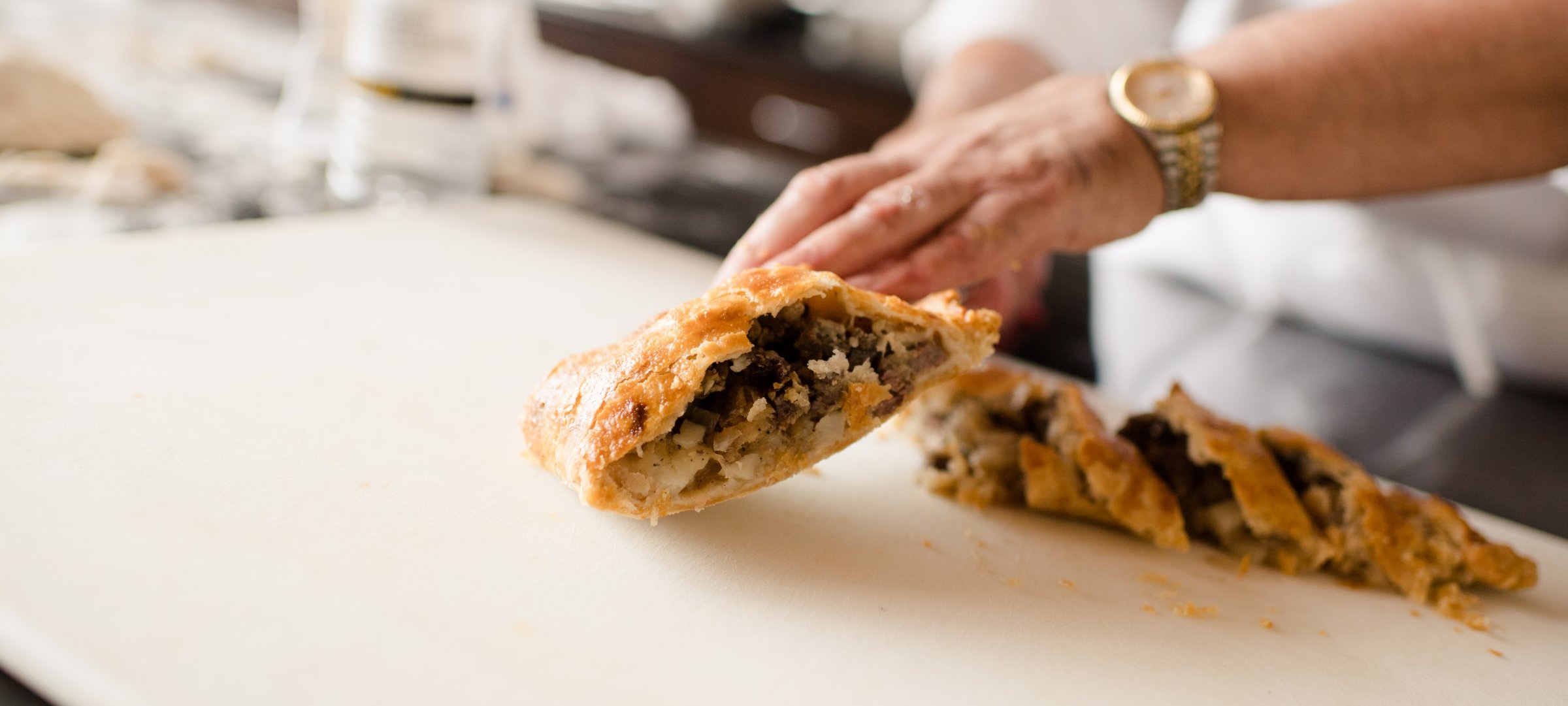 Chef showing the inside of a Cornish pasty