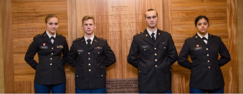 Michigan tech students part of the United States Army standing with the War Memorial Wall