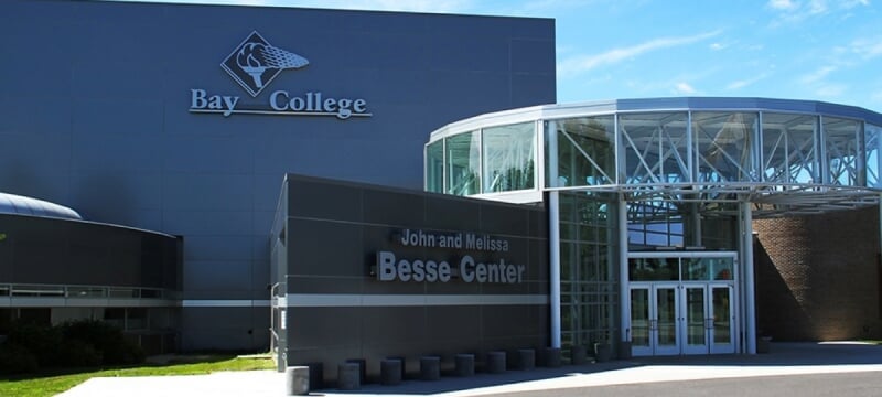 The exterior of the John and Melissa Besse Center at Bay College, featuring a modern glass and steel entrance.