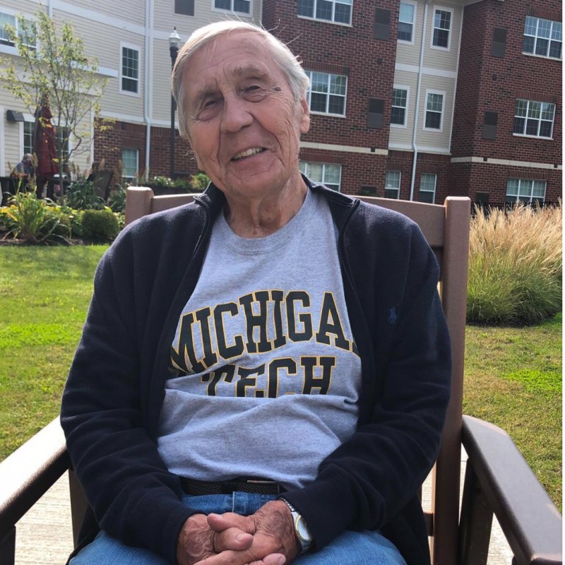 George Mackey sits wearing a Michigan Tech shirt