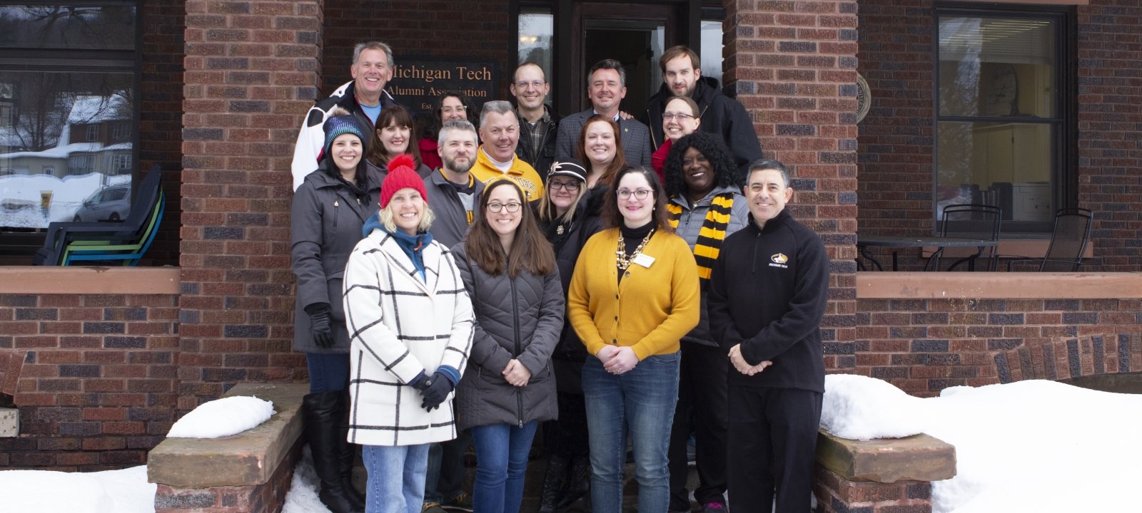 Alumni board standing in front of Alumni House