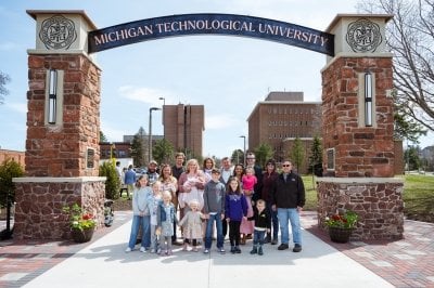 Mike Trewhella '78 and family stand under the Alumni Gateway Arch.