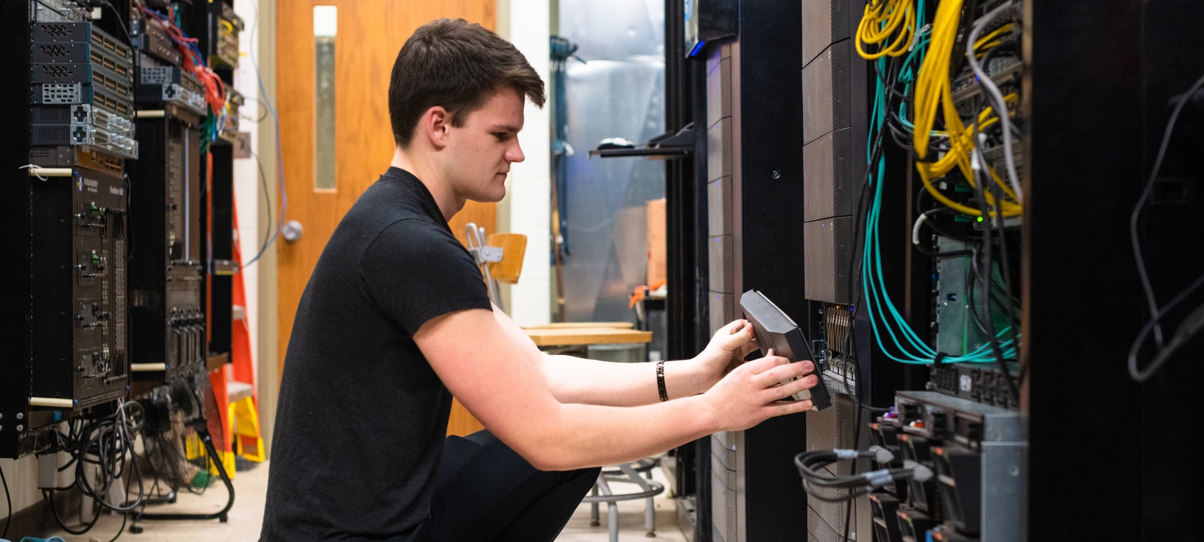 Student working on equipment in a server room.