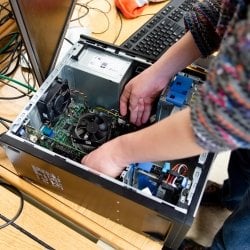 Person reaching into an open CPU.