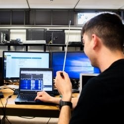 Student with antenna and laptop doing testing.