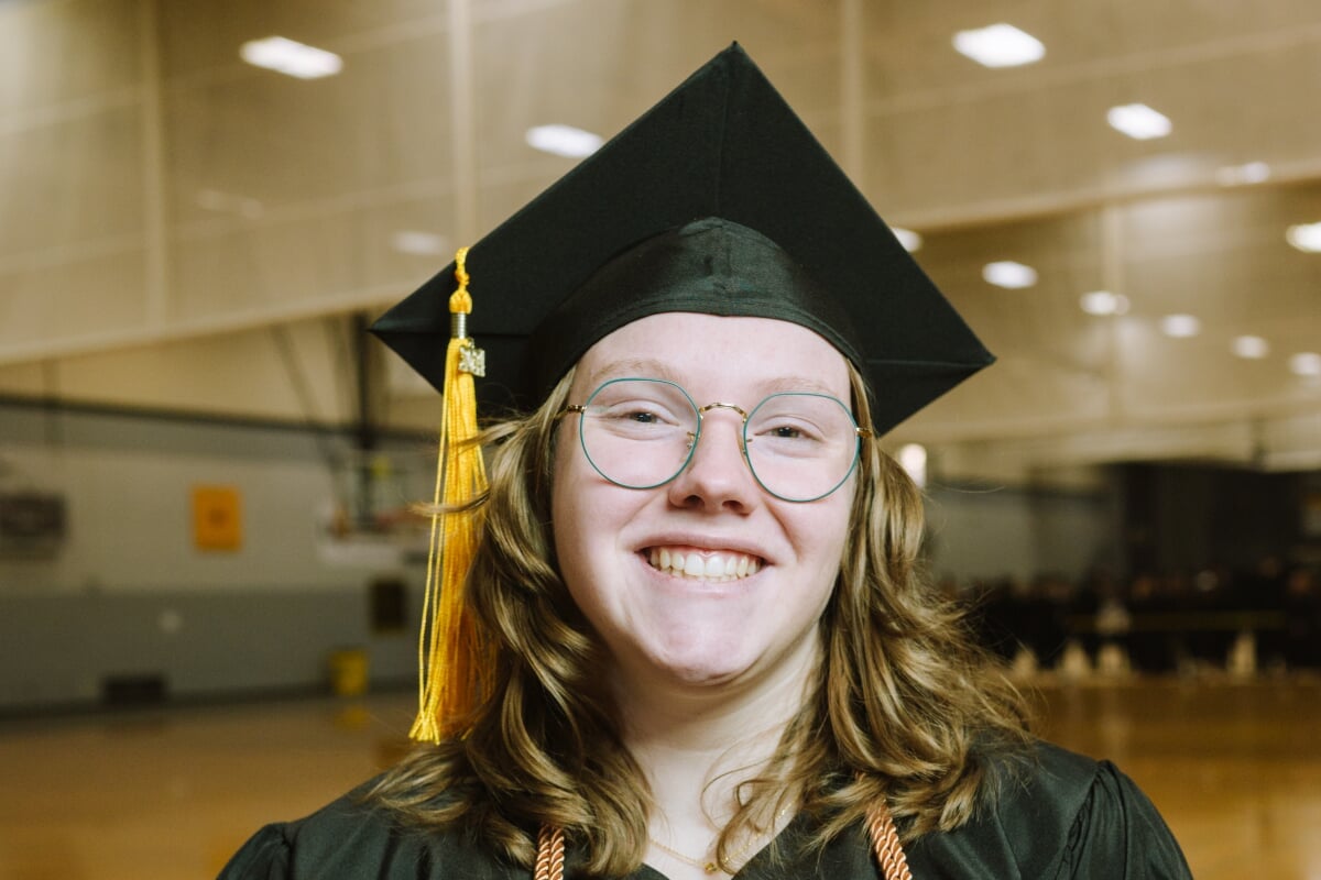 A college of computing cybersecurity grad from Michigan Tech smiles on graduation day
