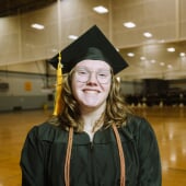 A college of computing cybersecurity grad from Michigan Tech smiles on graduation day