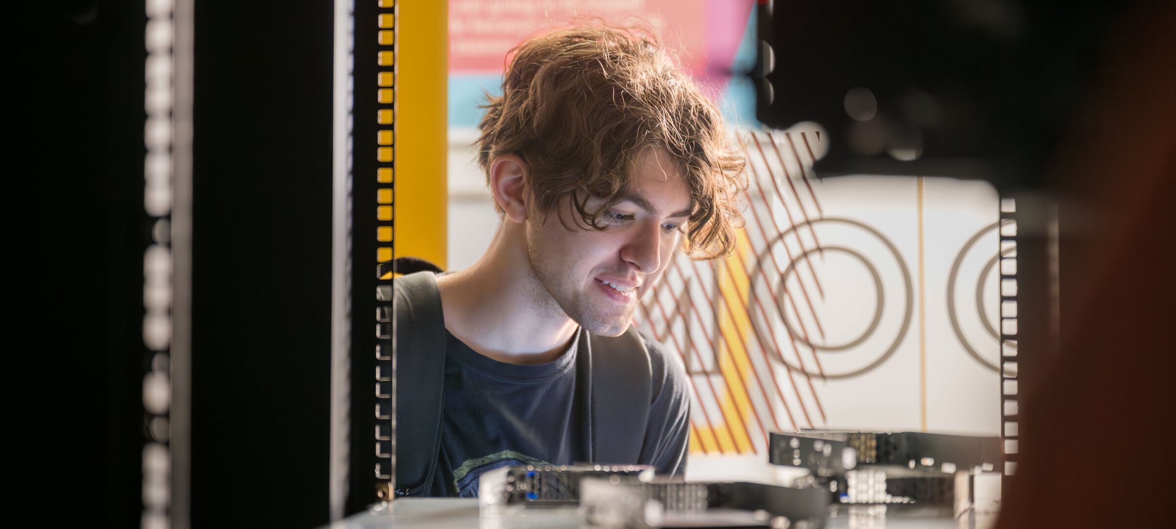 A cybersecurity student examines computing hardware at Michigan Tech
