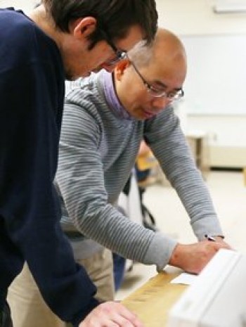 Faculty and students working together at a table in the lab.