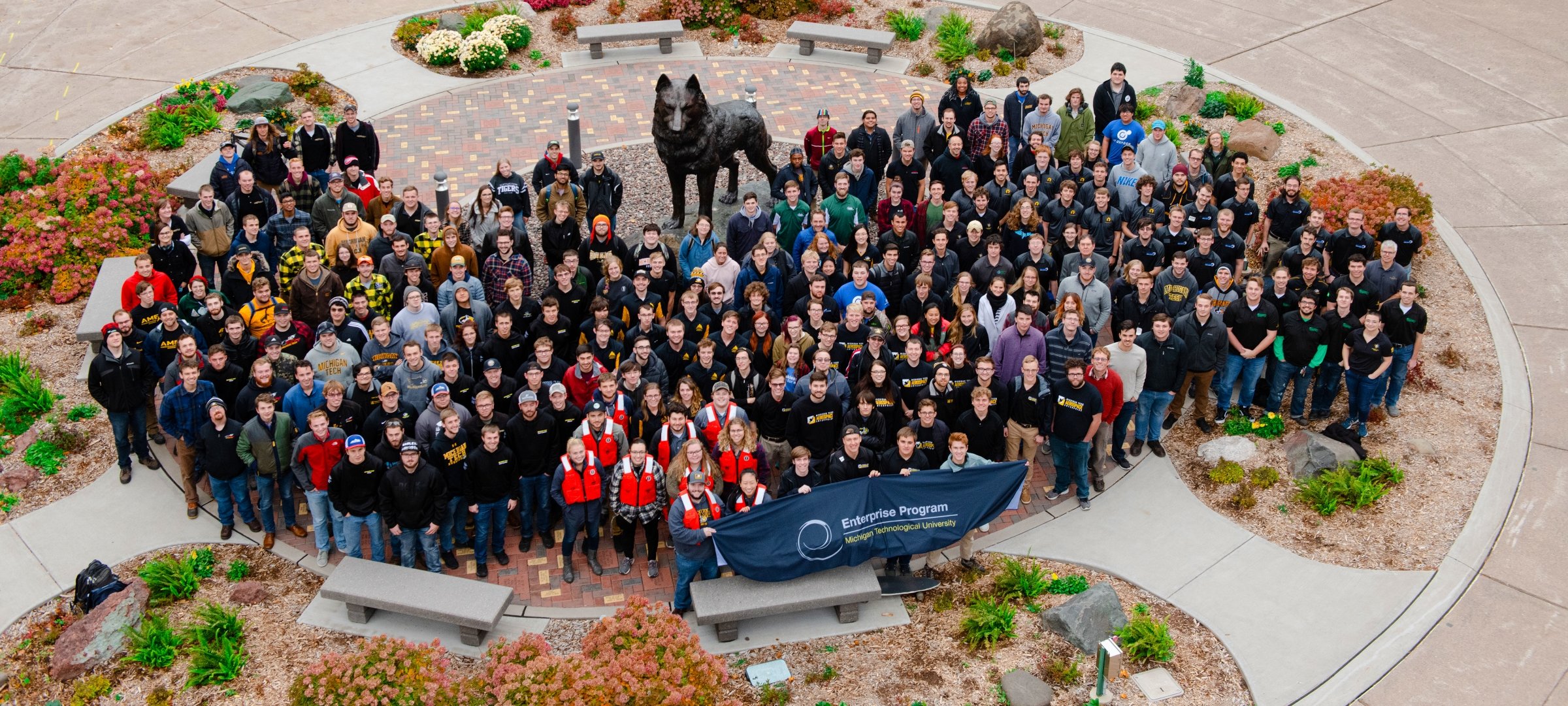 Group photo of Enterprise students standing around the Husky statue.