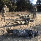 Cadets laying on the ground face up with commander over