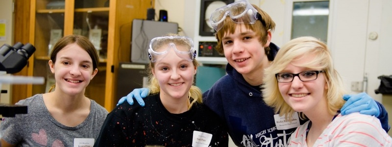 Four High School students pose for a photo in the Biological Sciences Lab