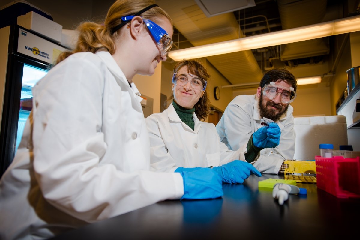 Researchers wearing lab coats working in a Biological Sciences lab.