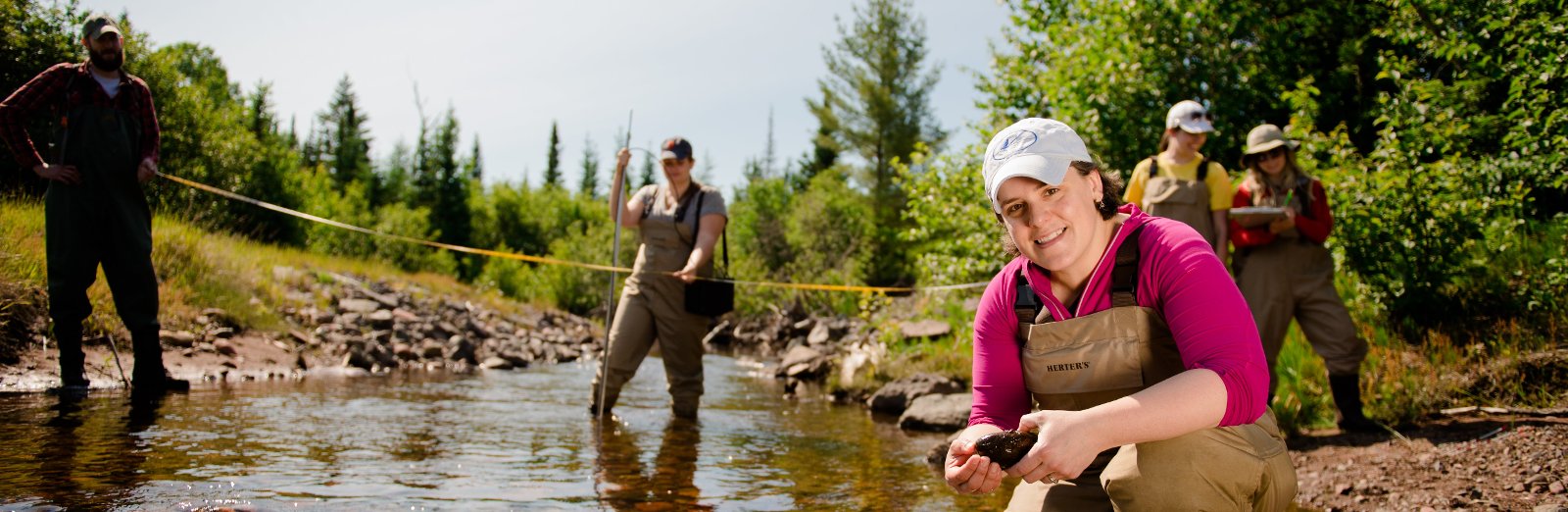 SEveral researchers collecting data from a stream.