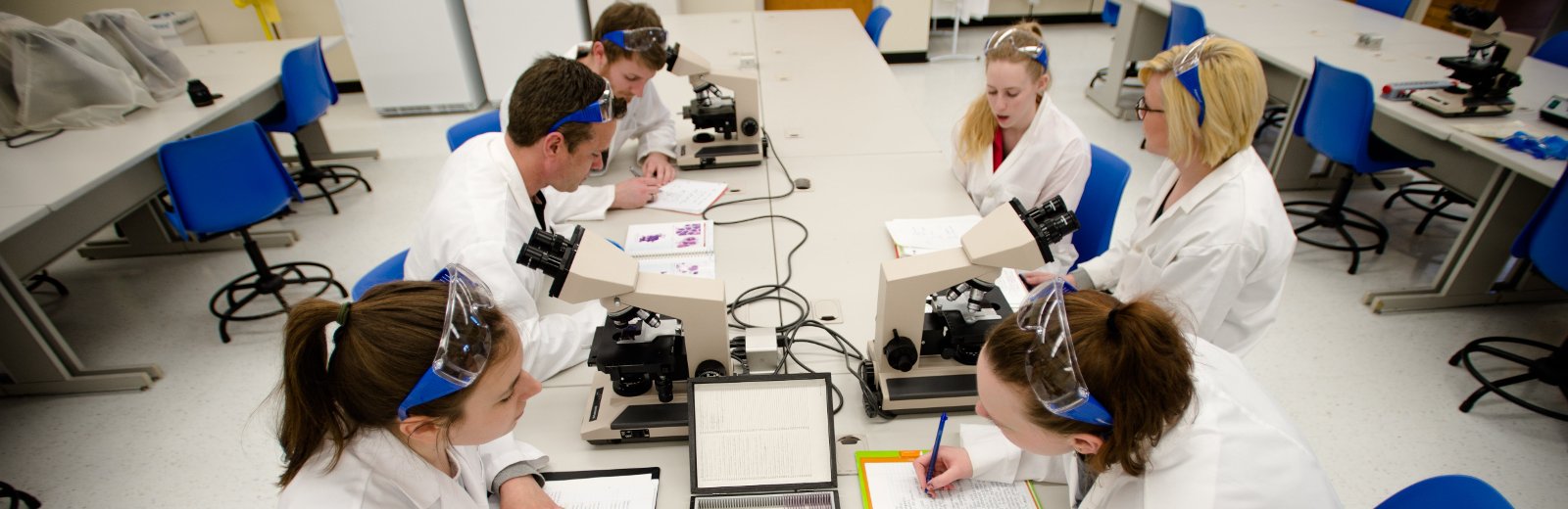 Students working at a table with microscopes.