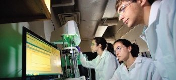 Students working at a computer in a lab.