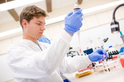 Student with a pipette for experiment