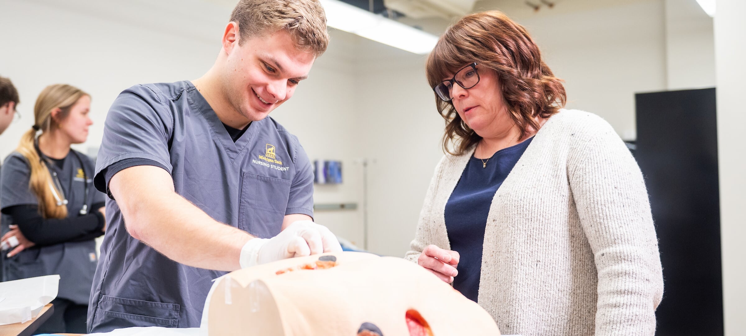 Faculty advising a nursing student during an activity.