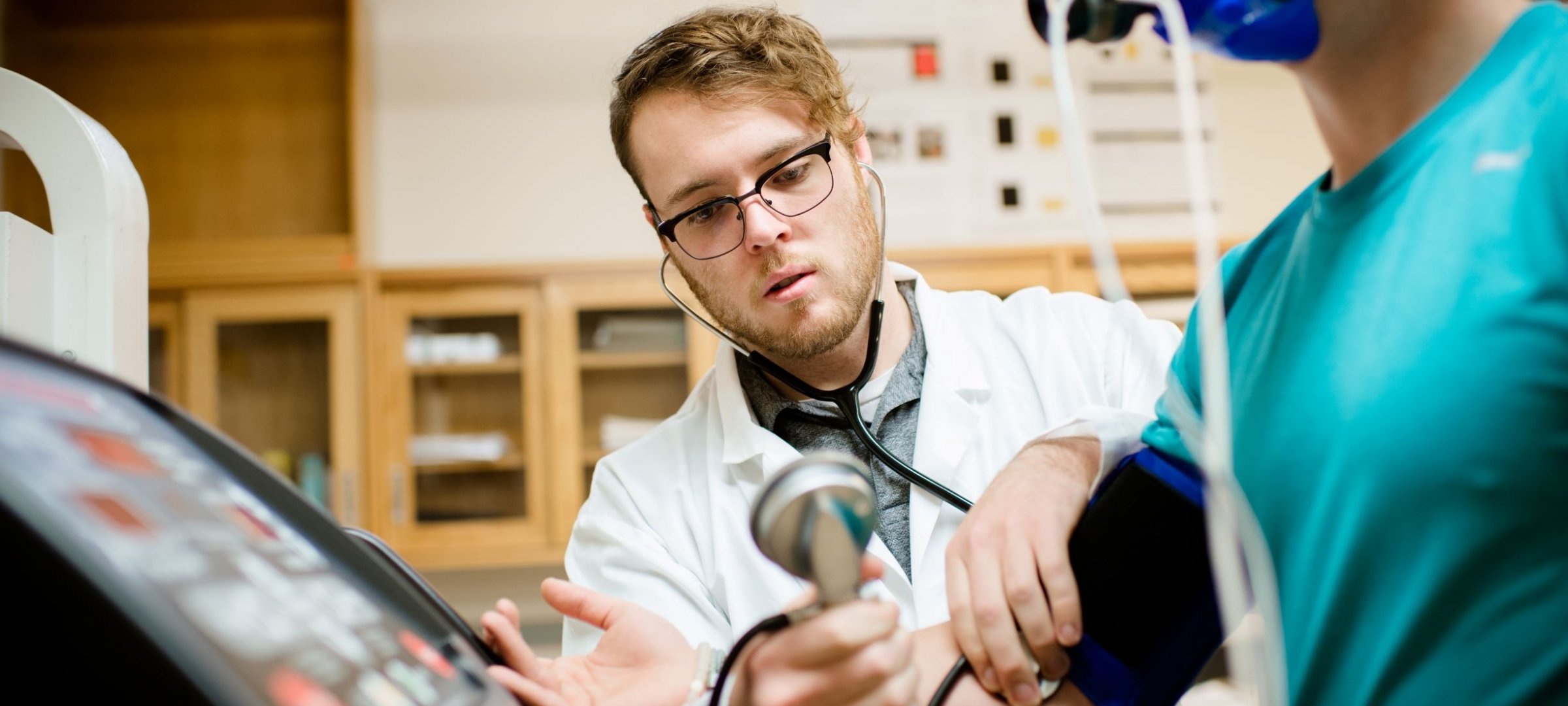 Student assessing blood pressure in a research lab.