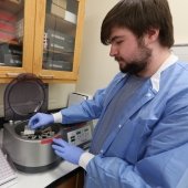 Student loading a centrifuge with blood bank gel cards.